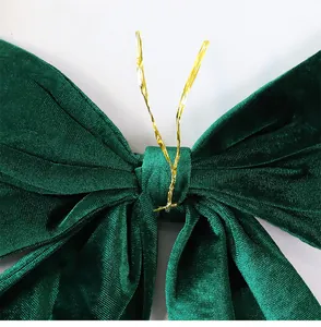 Detailed macro view of dark green velvet Christmas bow decoration with gold wire tie