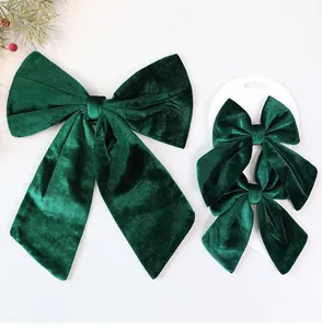 Detailed view of dark green velvet Christmas bow decorations in large and small sizes