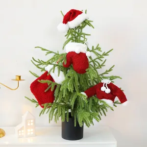 Mini plush red and white Christmas sweater hat and stocking ornaments on a green tree