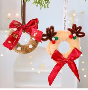 Vista detallada de dos coronas de Navidad de limpiapipas DIY con lazos rojos festivos