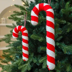 Festive red and white striped candy cane ornaments hanging on a green Christmas tree