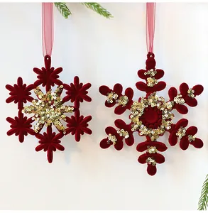 Close-up of red flocked snowflake ornaments with sparkling gold sequins and ribbons
