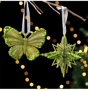 Nahaufnahme von grünen Pailletten-Schmetterlings- und Stern-Weihnachtsanhängern.