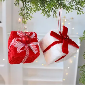 Detalle de adornos de caja de regalo de peluche rojos y blancos en árbol de Navidad