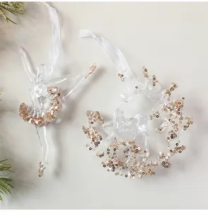 Detailansicht klarer Acryl-Weihnachtsschmuck mit schimmernden Goldpailletten und Bändern
