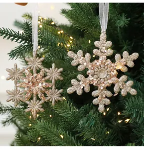 Detaillierte Ansicht champagnergoldener glitzernder Schneeflocken am Weihnachtsbaum