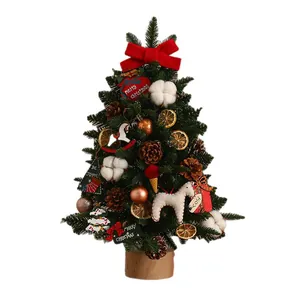 Mini desktop Christmas tree set with red bow ornaments and pine cones on white background