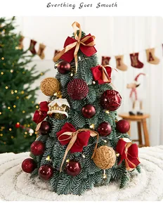 Vista detallada de un árbol de Navidad de mesa decorado con lazos rojos y adornos festivos