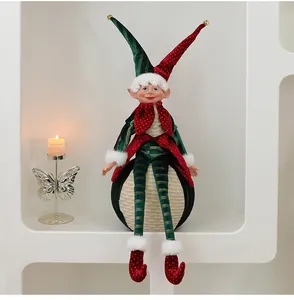 Detailansicht einer rot-grünen Weihnachts-Elfenpuppe auf einer festlichen Kugel