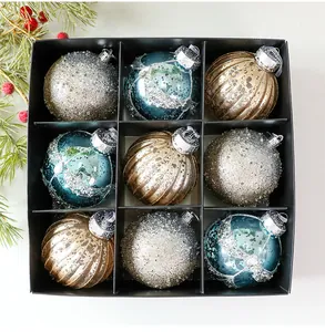 Vista superior detallada de nueve bolas de Navidad pintadas en una caja negra