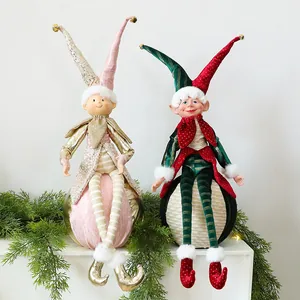 Nahaufnahme von festlichen Weihnachts-Elfenfiguren auf Kugeln mit Tannengrün-Deko.