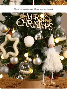 Close-up of mini Christmas tree featuring white angel doll and silver ornaments