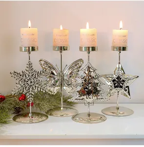 Nahaufnahme von vier eleganten silbernen Metallkerzenhaltern mit brennenden Kerzen für Deko