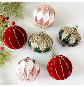Vista detallada de bolas de Navidad decorativas de 8cm con acabados de terciopelo y purpurina.