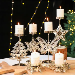Nahaufnahme goldener Weihnachtskerzenhalter aus Eisen in Schneeflocken- und Baumform.