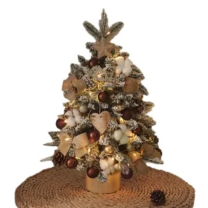 Elegant mini tabletop Christmas tree with artificial snow, warm LED lights, and rustic ornaments