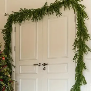 Ghirlanda di pino di Norfolk artificiale su doppia porta bianca per decoro festivo
