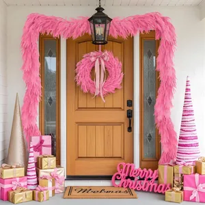 Ghirlanda e corona di pino Norfolk rosa decorano una porta con scatole regalo festive.