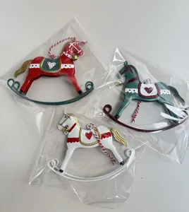 Three vintage iron rocking horse Christmas ornaments in red, green, and white colors.