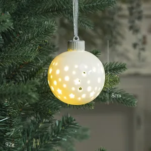 Bola de Navidad luminosa de cerámica blanca de 8cm con estrellas en un árbol verde