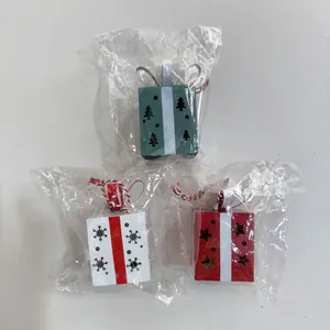 Vue détaillée de mini boîtes cadeaux de Noël en fer de couleurs vert, blanc et rouge