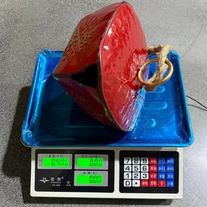 Détail d'une cloche vintage en métal rouge avec flocon pesant 0,400 kg sur balance