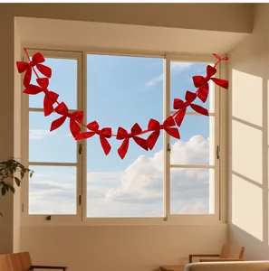 Red ribbon bow garland hanging on a window for festive Christmas decoration