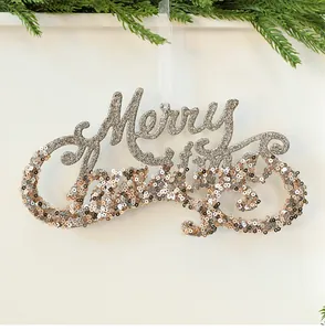 Detailansicht von champagnergoldener Merry Christmas Deko mit Glitzer-Pailletten