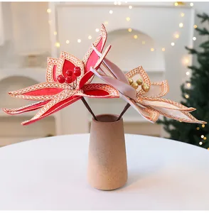 Détail de fleurs de Noël en velours artificiel dans un vase élégant.