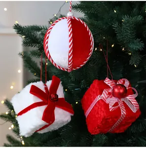 Primer plano de adornos navideños: cajas de regalo de peluche y bolas de rayas rojas.
