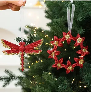 Close-up detail of red glitter dragonfly and wreath Christmas ornaments on a tree.