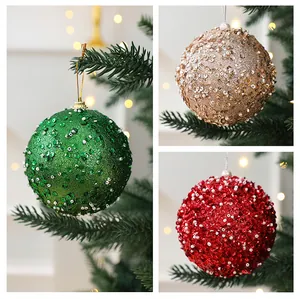 Détail de boules de Noël de 10cm avec paillettes et perles en vert, or et rouge