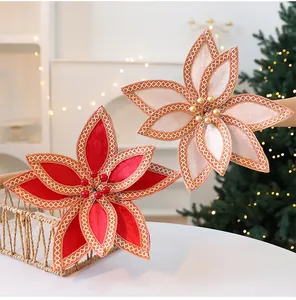 Gros plan de fleurs de poinsettia en velours rouge et beige pour sapin de Noël.