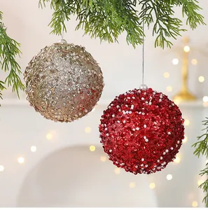 Vue détaillée des boules de Noël à paillettes rouges et champagne avec des perles