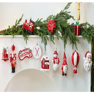 Gevarieerde collectie feestelijke geblazen kerstornamenten hangend aan een schouwdecoratie