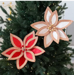 Gros plan de fleurs de poinsettia en velours rouge et champagne sur un sapin de Noël