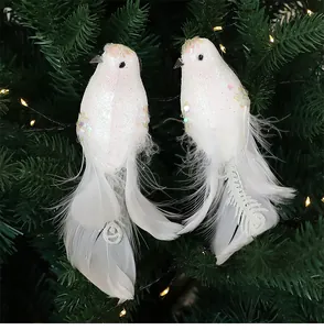 Detail van witte glittervogel ornamenten met echte verentail op een kerstboom decoratie.