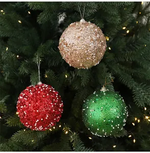 Gros plan de boules de Noël de 10 cm avec paillettes et perles sur un arbre festif.