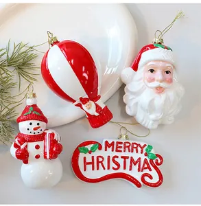 Close-up van rood-witte kerstversieringen met de kerstman en sneeuwpop om op te hangen.