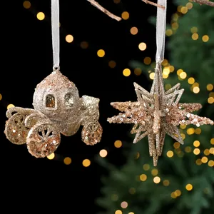 Champagnegoldene Glitzer-Kürbiskutsche und Stern-Weihnachtsanhänger mit weißen Bändern.
