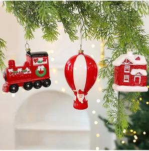 Detailweergave van rode kerstversieringen met trein-, heteluchtballon- en huisvormen