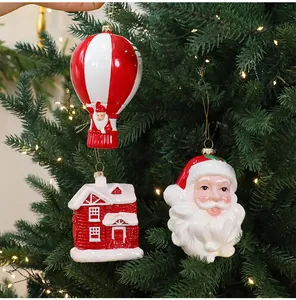 Detail van kerstboomversieringen in de vorm van de Kerstman, een huis en een luchtballon.