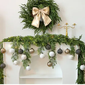 Detail showing 8cm vintage Christmas balls hanging on a lush green mantle garland.