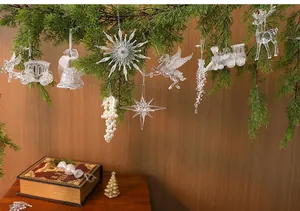 Various transparent acrylic ice crystal ornaments hanging on Christmas tree branches