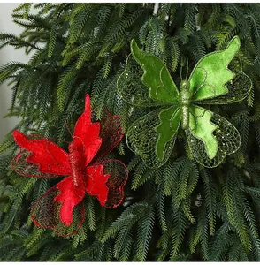 Close-up detail of red and green glitter fabric butterfly ornaments on a festive tree