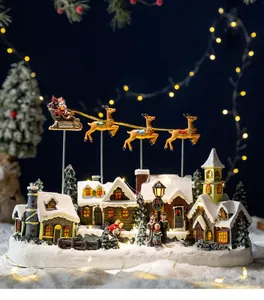 Detailed view of a lit Christmas snow village with Santa's flying reindeer sleigh.