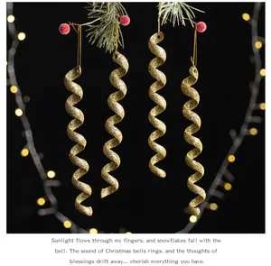 Detalle de adornos de carámbanos en espiral dorados con purpurina en una rama de Navidad