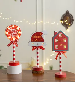 Macro detail of three festive wooden LED Christmas ornaments with Santa Stop Here text.