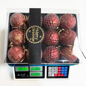 Detail view showing weight of 9-piece 8cm red textured Christmas ornaments in box