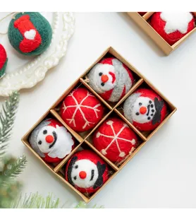 Vista detallada de seis adornos navideños de fieltro de lana hechos a mano en caja.